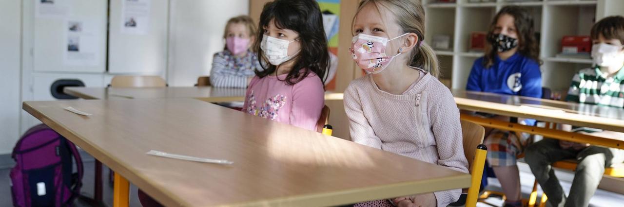 Grundschülerinnen sitzen mit Mund-Nasen-Schutz in einem Klassenraum in Düsseldorf, vor ihnen liegen die Corona-Teststäbchen für den sogenannten Lolli-Test Grundschülerinnen sitzen mit Mund-Nasen-Schutz in einem Klassenraum in Düsseldorf, vor ihnen liegen die Corona-Teststäbchen für den sogenannten Lolli-Test