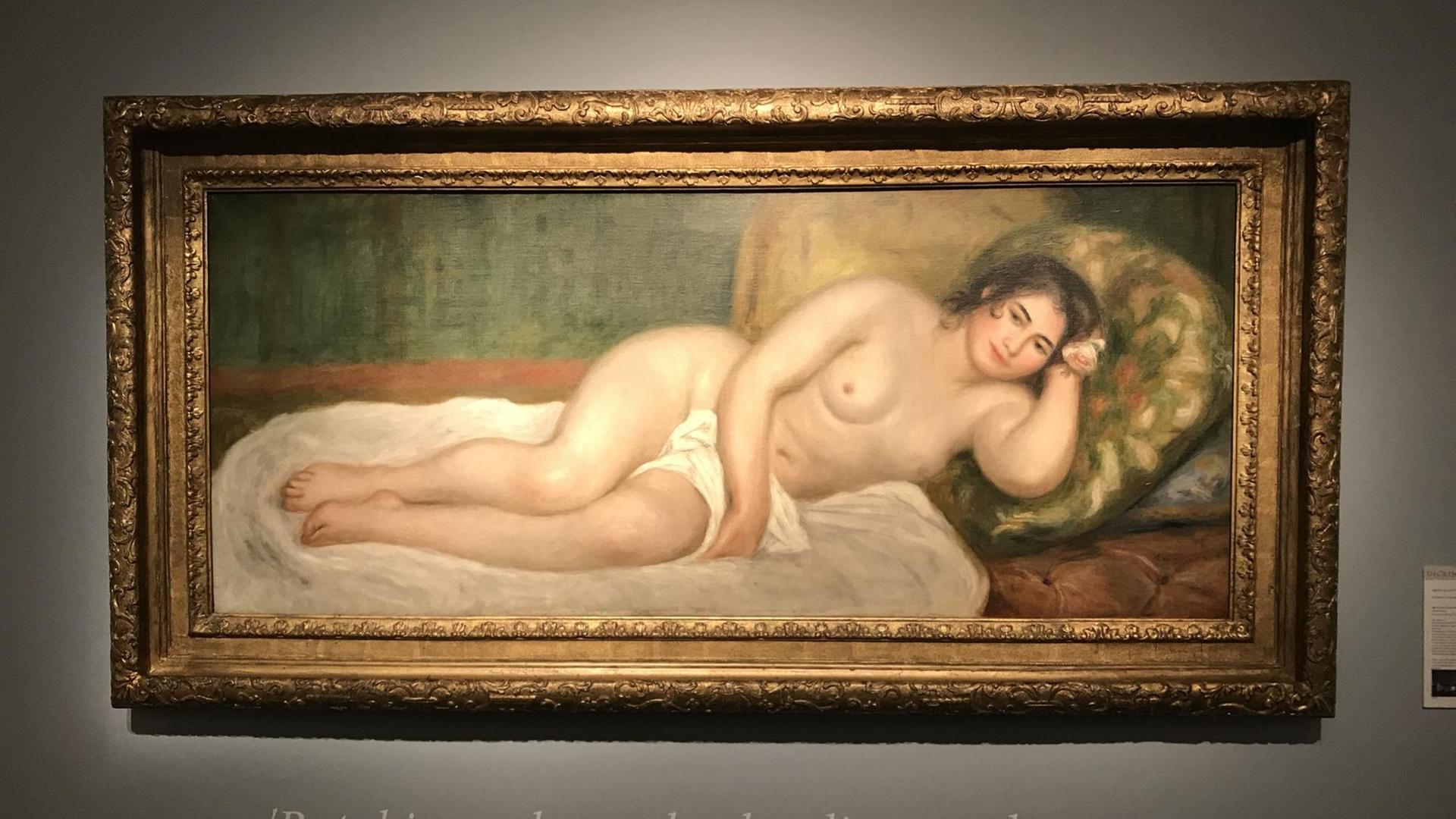 ein Gemälde von Renoir auf der eine Frau mit unverghülltem Oberkörper auf einem Sofa liegt. ein Gemälde von Renoir auf der eine Frau mit unverghülltem Oberkörper auf einem Sofa liegt.