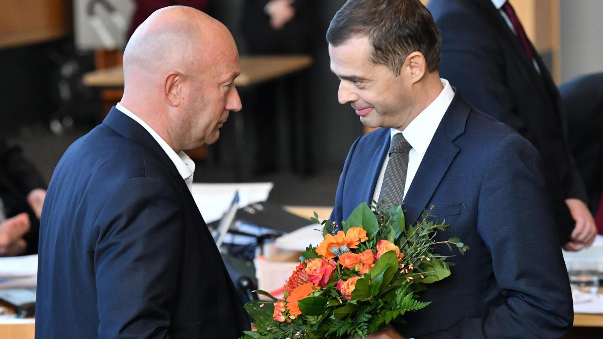 Mike Mohring, CDU-Fraktionschef, gratuliert Thomas Kemmerich (FDP), dem neuen Thüringer Ministerpräsidenten, mit einem Blumenstrauß. Mike Mohring, CDU-Fraktionschef, gratuliert Thomas Kemmerich (FDP), dem neuen Thüringer Ministerpräsidenten, mit einem Blumenstrauß.