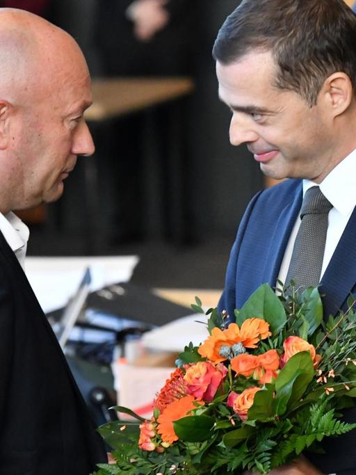 Mike Mohring, CDU-Fraktionschef, gratuliert Thomas Kemmerich (FDP), dem neuen Thüringer Ministerpräsidenten, mit einem Blumenstrauß.