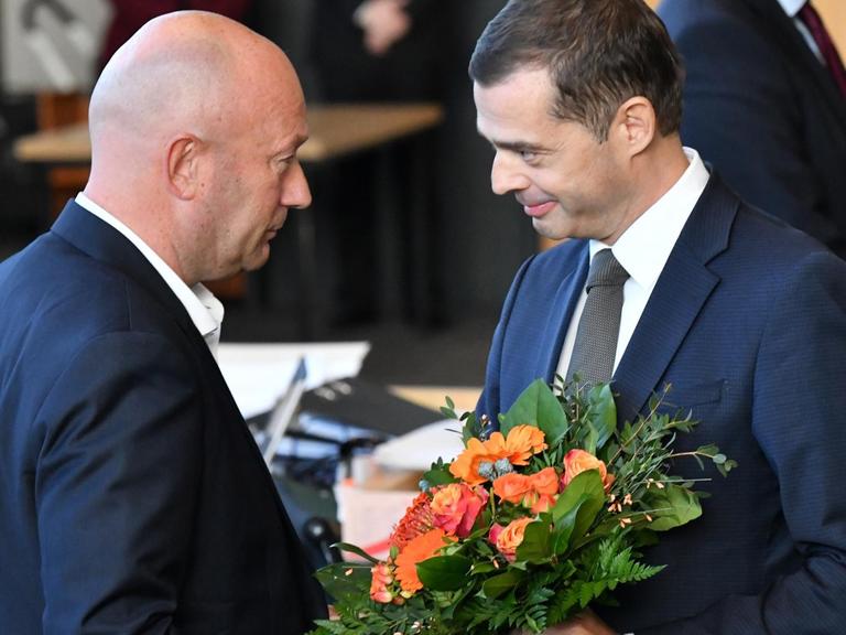 Mike Mohring, CDU-Fraktionschef, gratuliert Thomas Kemmerich (FDP), dem neuen Thüringer Ministerpräsidenten, mit einem Blumenstrauß.