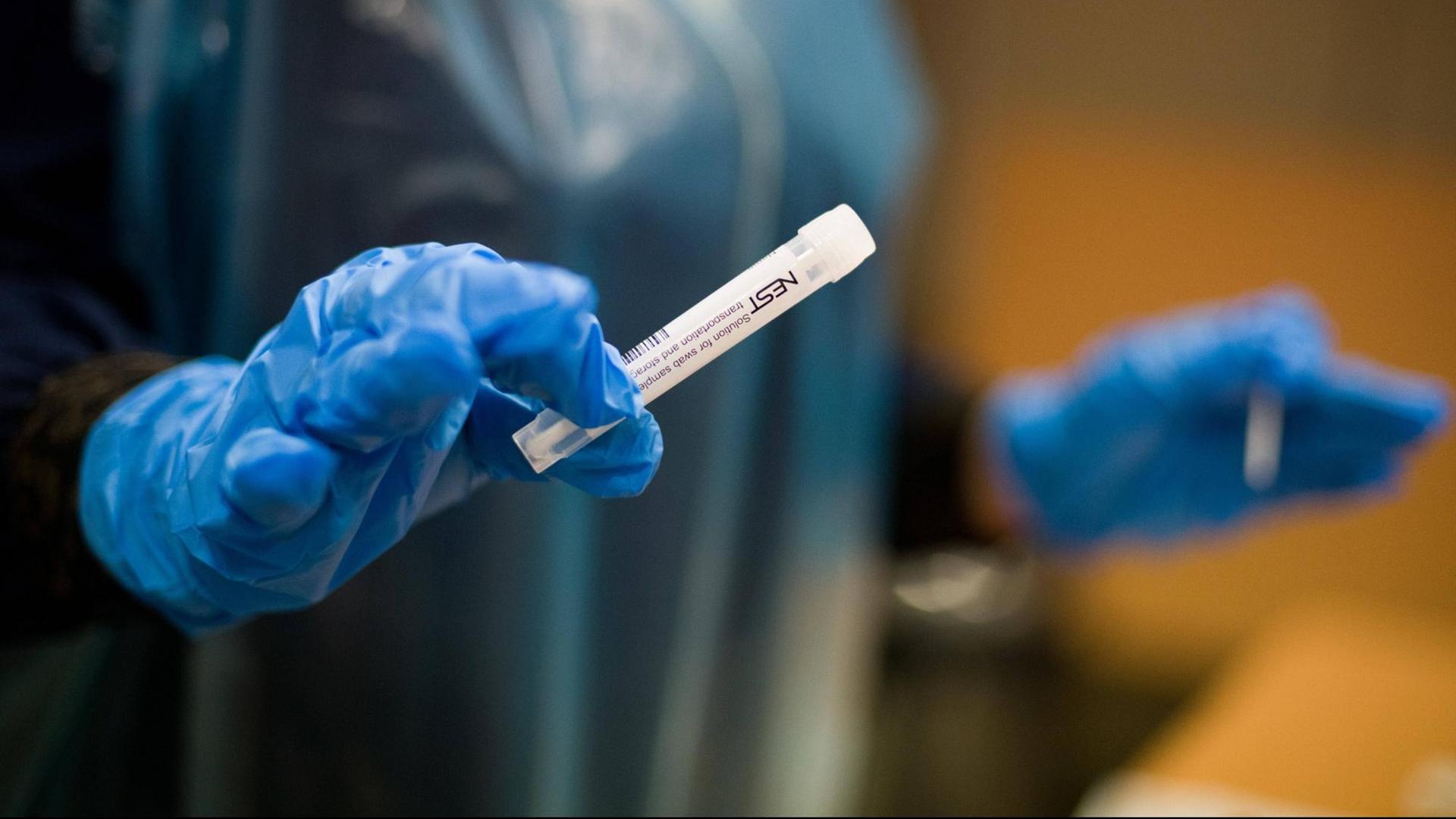 In Frankreich üben Angehörige des Zivilschutzes die Durchführung von Corona-Tests. Eine Hand mit blauem Plastikhandschuh hält ein Test-Röhrchen. In Frankreich üben Angehörige des Zivilschutzes die Durchführung von Corona-Tests. Eine Hand mit blauem Plastikhandschuh hält ein Test-Röhrchen.