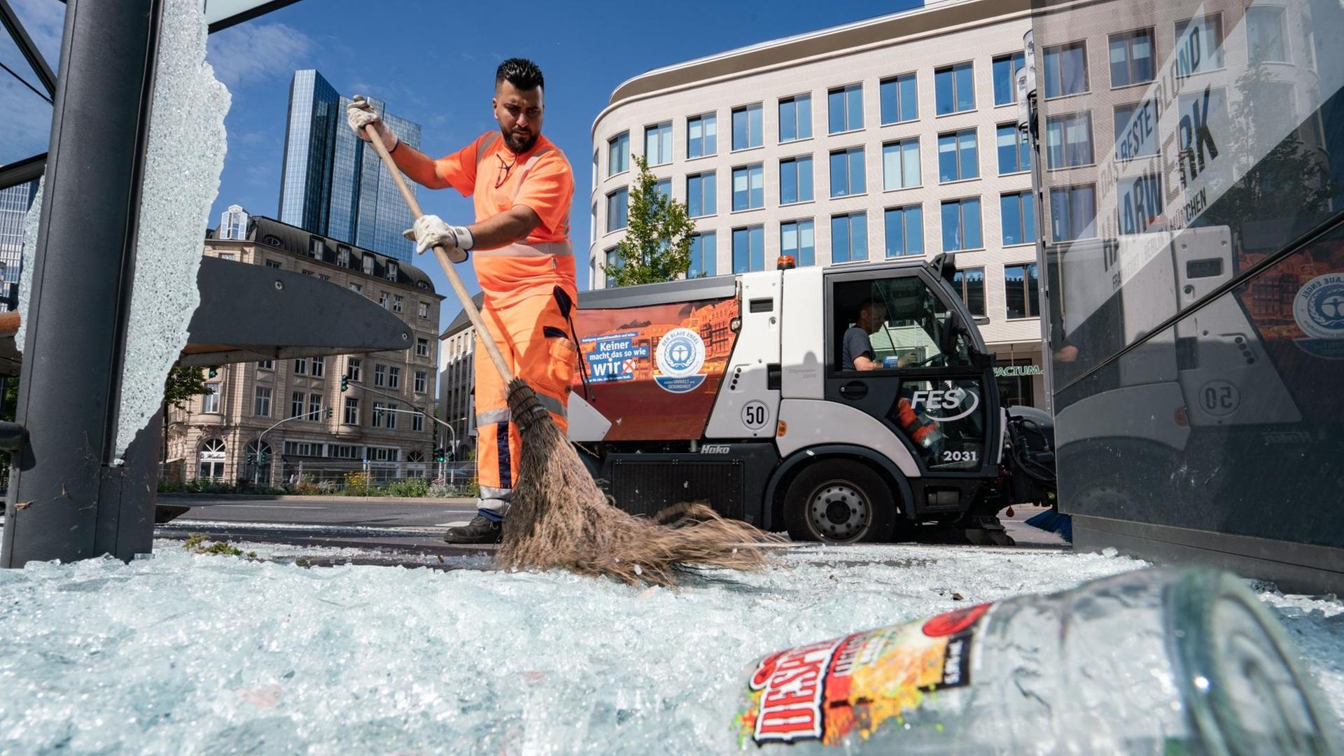 19.07.2020, Hessen, Frankfurt/Main: Mitarbeiter der Stadtreinigung beseitigen am Morgen vor der Alten Oper Scherben der zertrümmerten Scheiben einer Bushaltestelle. In der Nacht zum 19.07.2020 ist es auf dem Opernplatz zu gewalttätigen Krawallen gekommen. Wie die Polizei mitteilte, hatten rund 3000 Menschen Partys gefeiert, als die Randale ausbrachen. 39 Menschen seien daraufhin festgenommen worden, acht davon seien am Sonntagmorgen noch in Gewahrsam gewesen. Foto: Frank Rumpenhorst/dpa | Verwendung weltweit 19.07.2020, Hessen, Frankfurt/Main: Mitarbeiter der Stadtreinigung beseitigen am Morgen vor der Alten Oper Scherben der zertrümmerten Scheiben einer Bushaltestelle. In der Nacht zum 19.07.2020 ist es auf dem Opernplatz zu gewalttätigen Krawallen gekommen. Wie die Polizei mitteilte, hatten rund 3000 Menschen Partys gefeiert, als die Randale ausbrachen. 39 Menschen seien daraufhin festgenommen worden, acht davon seien am Sonntagmorgen noch in Gewahrsam gewesen. Foto: Frank Rumpenhorst/dpa | Verwendung weltweit