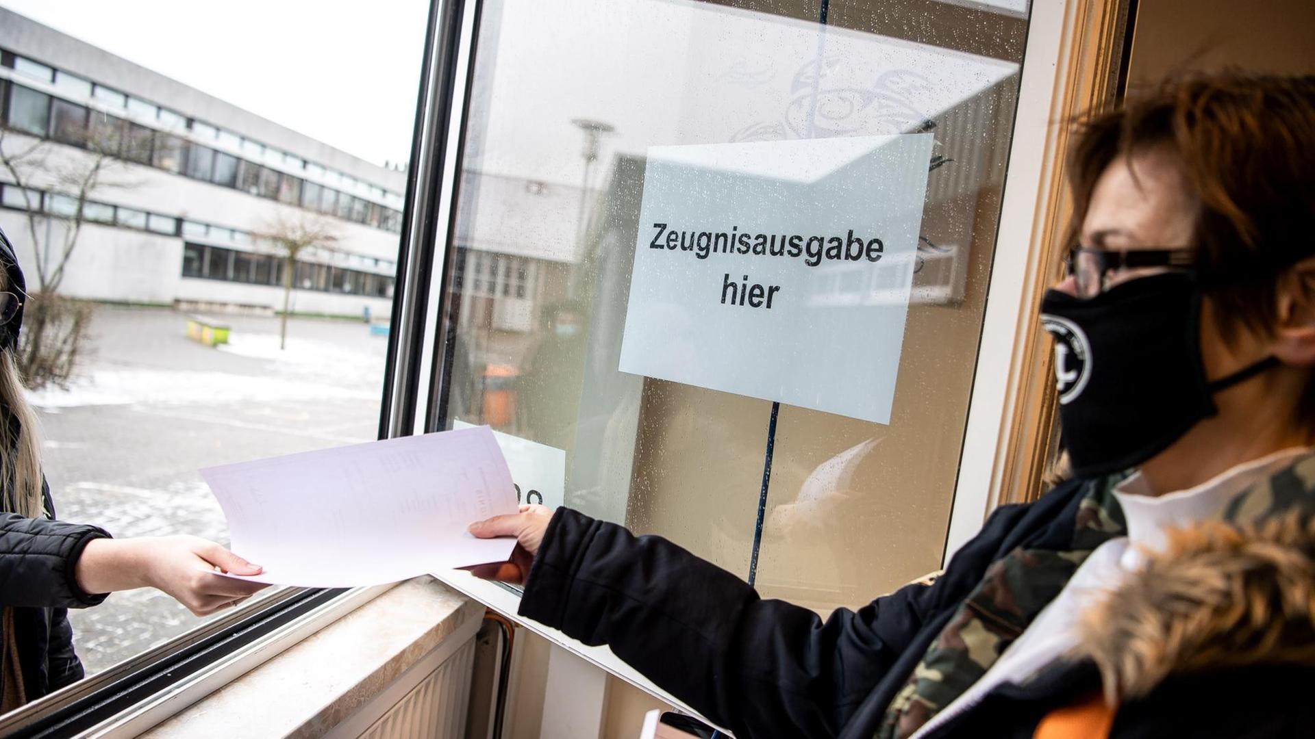 Kerstin Schermer, Sekretärin an der Oberschule Rodenkirchen, reicht den Schülerinnen und Schülern die Zeugnisse aus dem Sekretariats-Fenster. Kerstin Schermer, Sekretärin an der Oberschule Rodenkirchen, reicht den Schülerinnen und Schülern die Zeugnisse aus dem Sekretariats-Fenster.