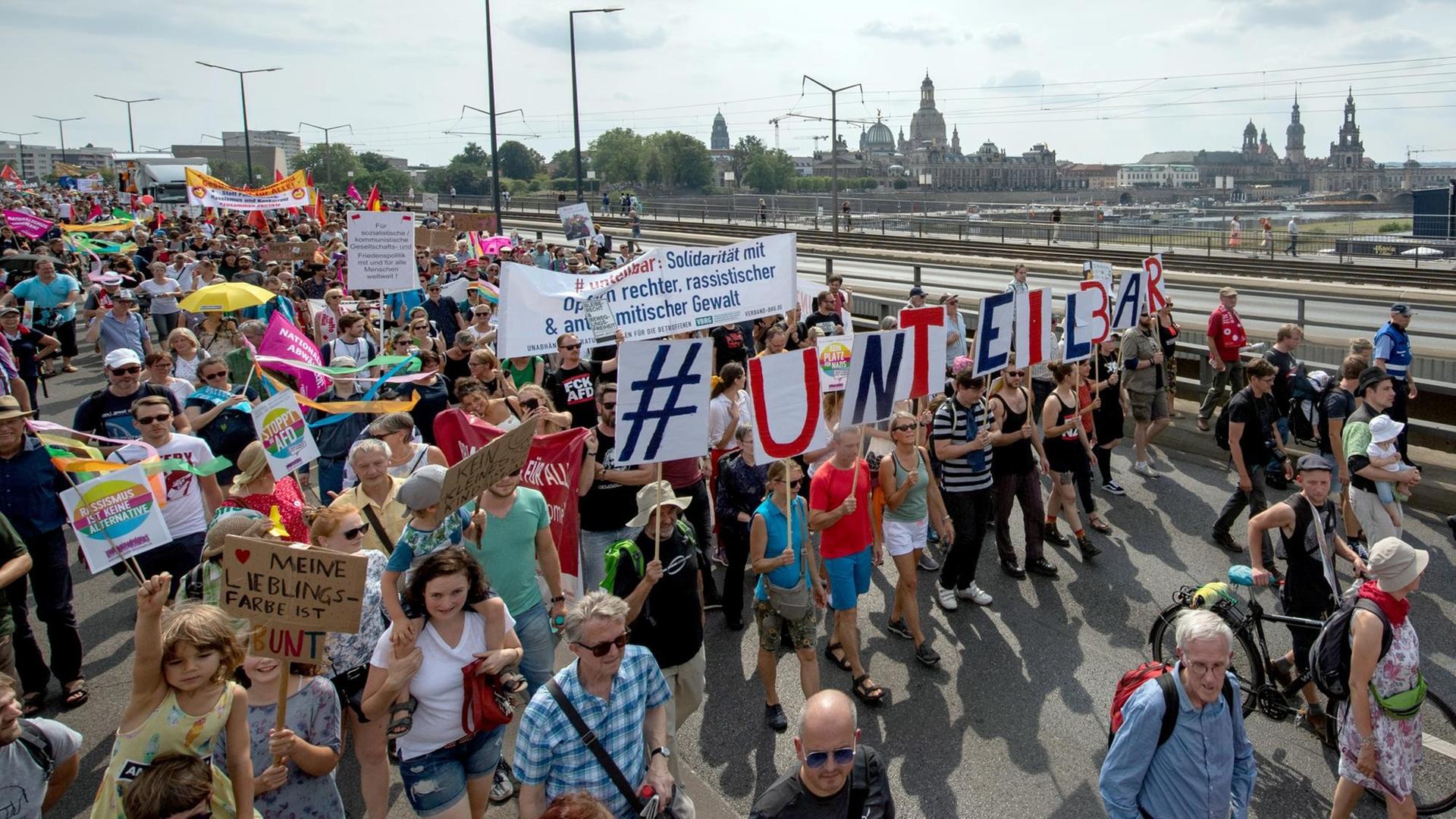 Anhänger des Bündnisses #unteilbar gehen während einer Demonstration über die Carolabrücke vor der historischen Altstadtkulisse von Dresden. Anhänger des Bündnisses #unteilbar gehen während einer Demonstration über die Carolabrücke vor der historischen Altstadtkulisse von Dresden.