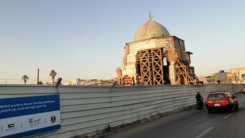 Die Nouri Moschee in Mossul mit Gerüst und Bauzaun.
