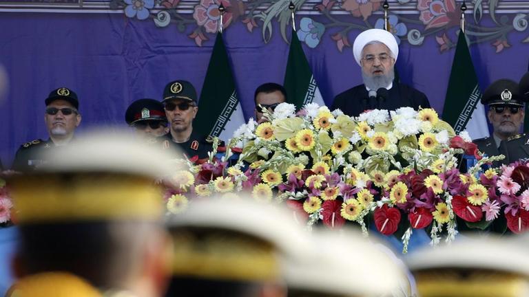 Soldaten stehen in Reih und Glied vor einer Bühne, auf der Rohani seine Ansprache hält. Das Foto ist auf den Präsidenten scharf gestellt. Soldaten stehen in Reih und Glied vor einer Bühne, auf der Rohani seine Ansprache hält. Das Foto ist auf den Präsidenten scharf gestellt.