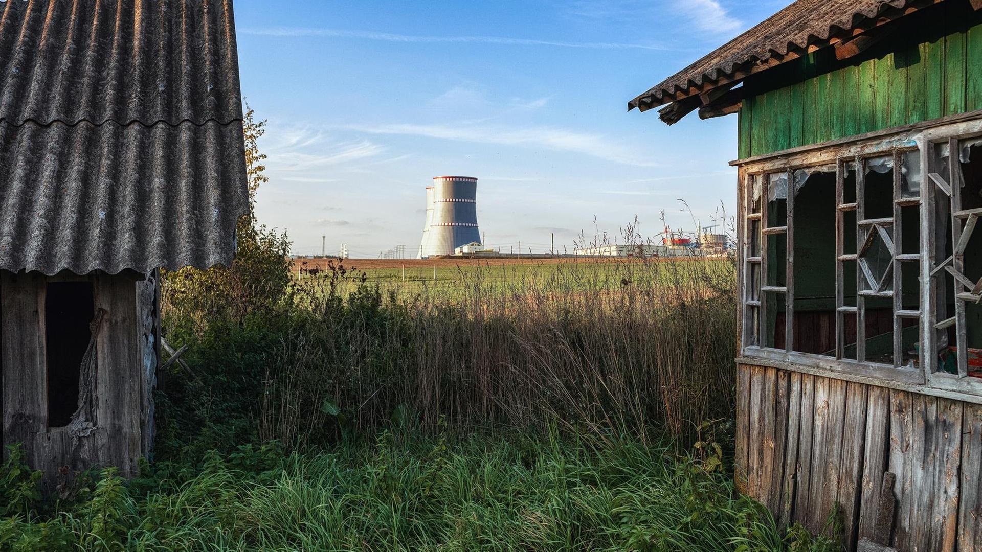 Blick von zwei Holzhütten aus auf die Kühltürme des AKW. Blick von zwei Holzhütten aus auf die Kühltürme des AKW.