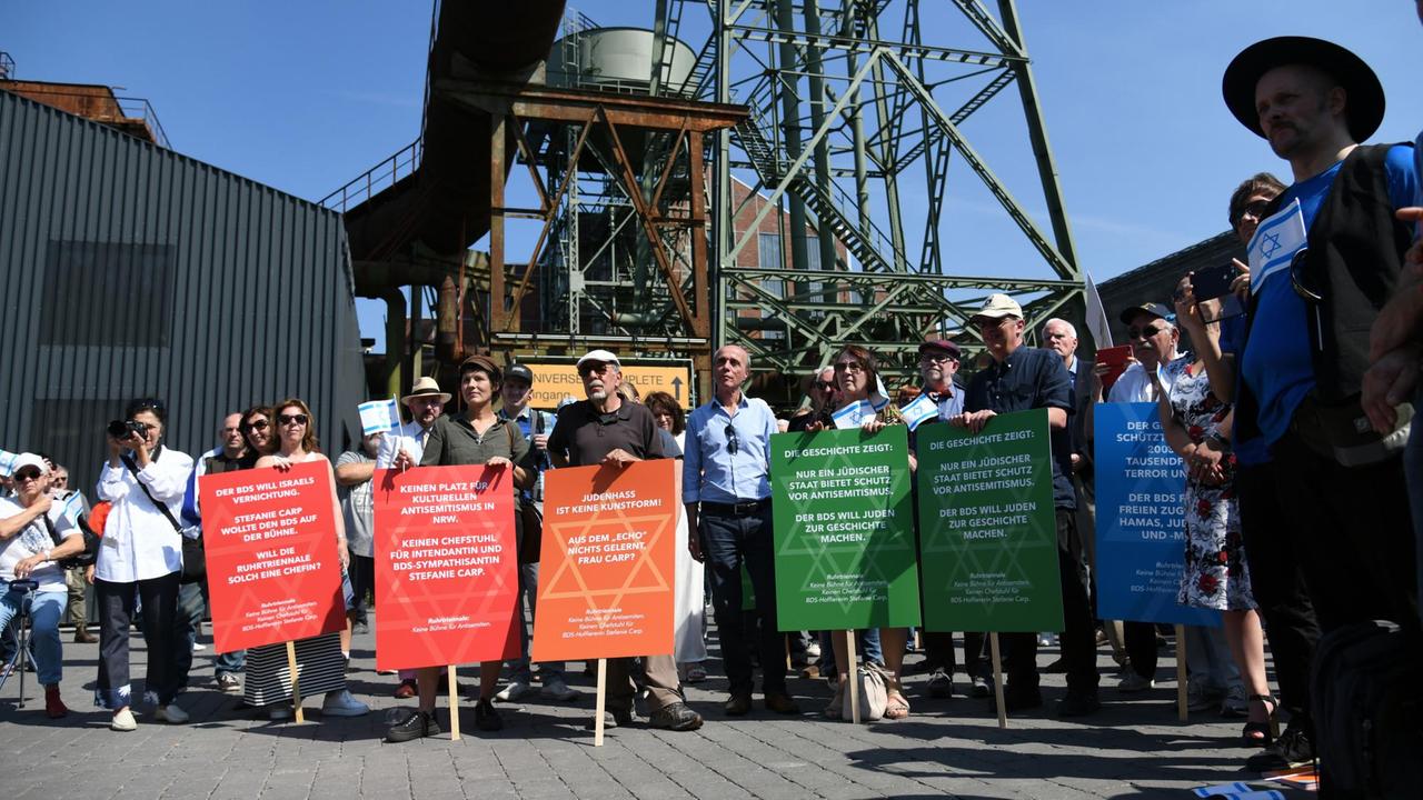 Israel-freundliche Demonstranten protestieren im Rahmen der Ruhrtriennale vor einer Podiumsdiskussion mit dem Titel "Freedom of Speech/Freiheit der Künste" an der Turbinenhalle. Die Intendantin Carp der Ruhrtriennale hatte die schottische Band, die der israelkritischen Bewegung BDS (Boycott, Divestment, Sanctions) nahesteht, eingeladen, dann aus- und dann wieder eingeladen. Israel-freundliche Demonstranten protestieren im Rahmen der Ruhrtriennale vor einer Podiumsdiskussion mit dem Titel "Freedom of Speech/Freiheit der Künste" an der Turbinenhalle. Die Intendantin Carp der Ruhrtriennale hatte die schottische Band, die der israelkritischen Bewegung BDS (Boycott, Divestment, Sanctions) nahesteht, eingeladen, dann aus- und dann wieder eingeladen.