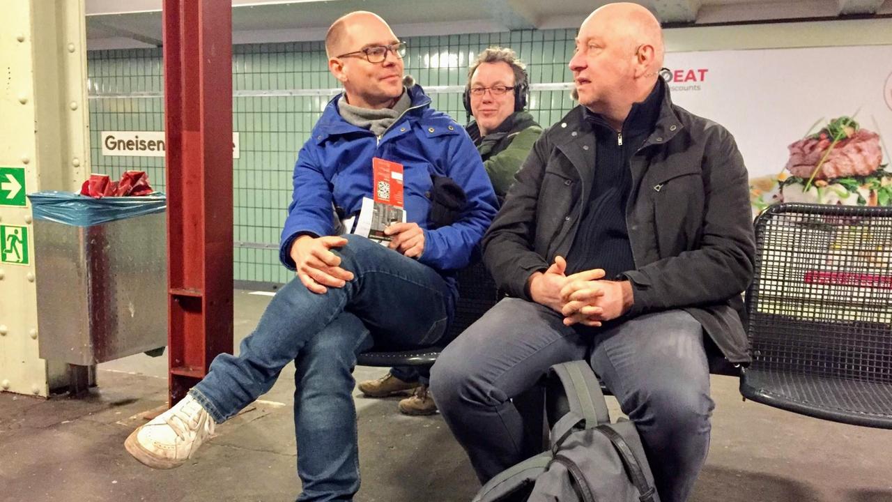 Der Berliner Kabarettist Horst Evers mit Moderator Korbinian Frenzel und Tontechniker Thomas Schütt in der U-Bahnstation Gneisenaustraße in Berlin-Kreuzberg.