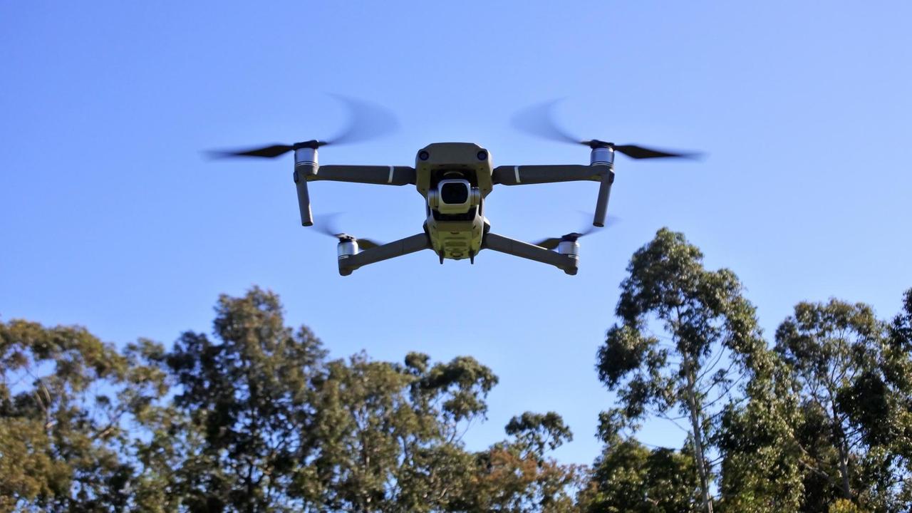 Front view of a Drone flying fast above forest treetops. Photo via Newscom picture alliance