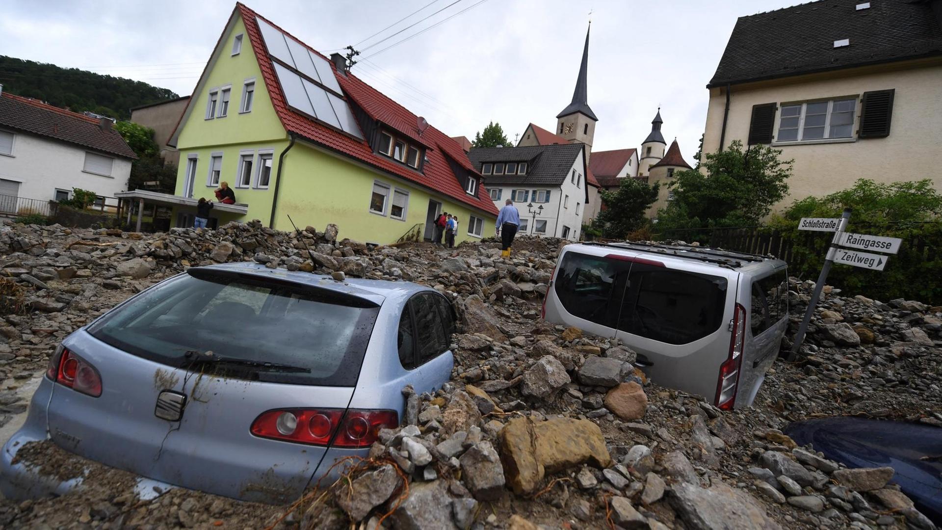 Zwei Autos sind unter eine Geröllmasse verschüttet Zwei Autos sind unter eine Geröllmasse verschüttet