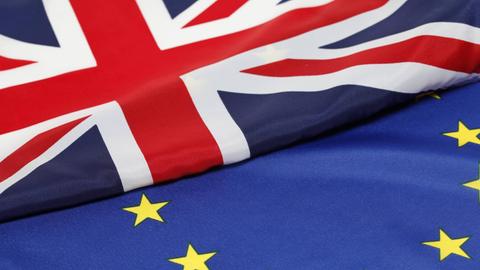 Farbfoto einer Europaflagge und einer britischen Flagge, Symbolfoto, Nahaunahme
