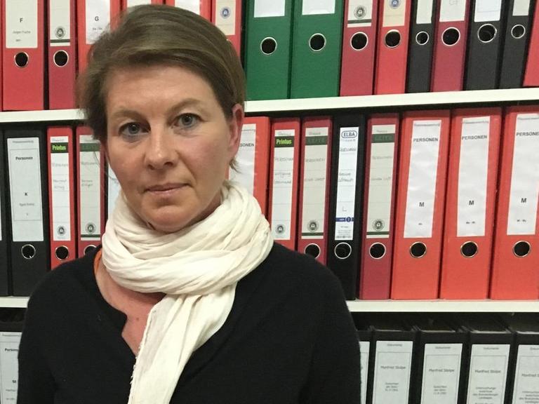 Die ehemalige rhythmische Sportgymnastin Susann Scheller steht vor einem Bücherregal.