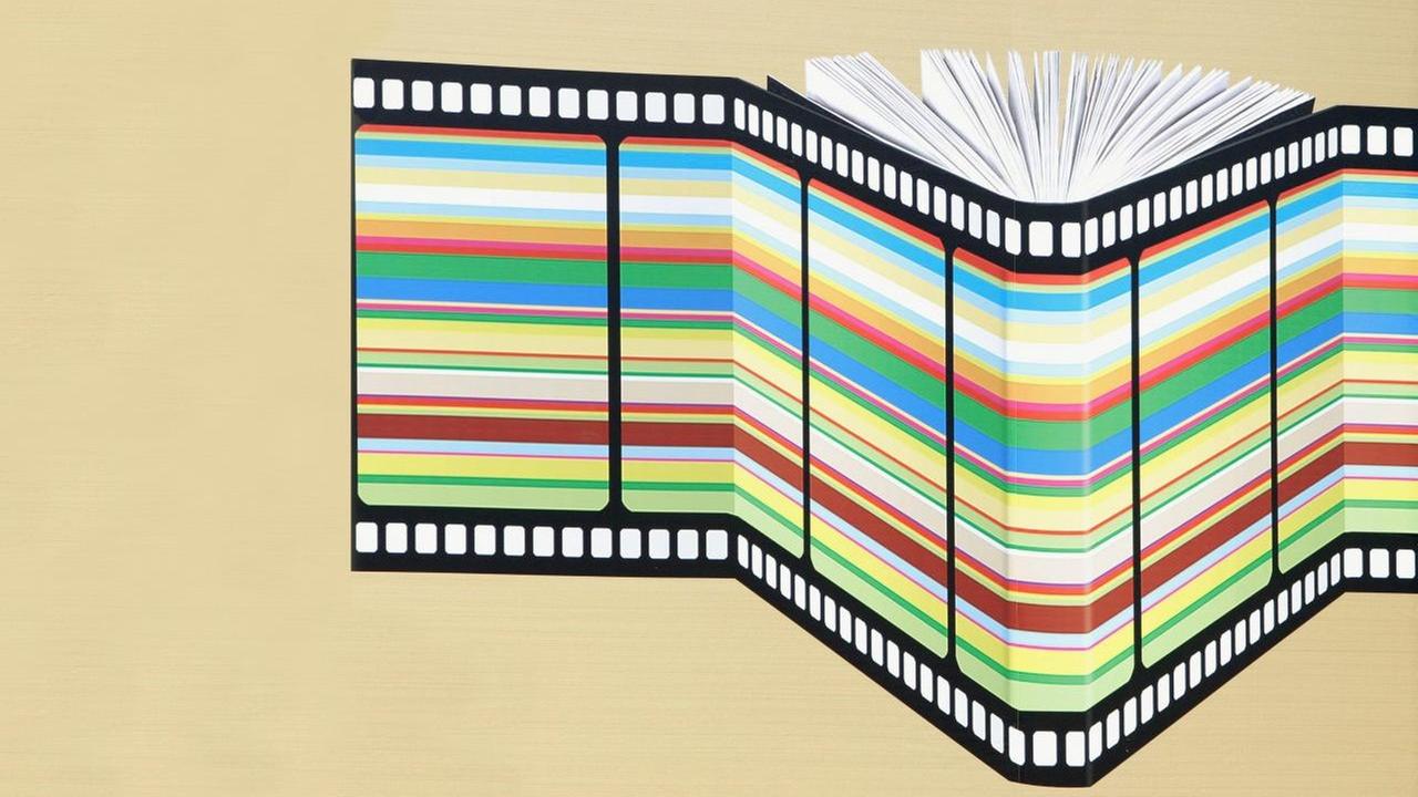 Illustration eines Buches, um das eine bunte Filmrolle gebunden ist. Illustration eines Buches, um das eine bunte Filmrolle gebunden ist.