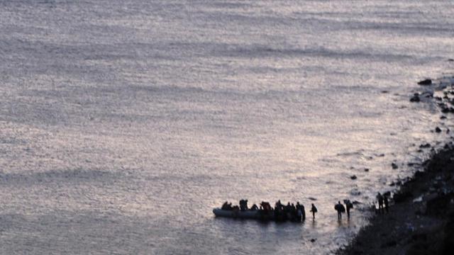 Schleuser weisen Flüchtlinge am Strand von Ayvacik am 03.11.2015 in ein Schlauchboot für die Überfahrt nach Lesbos.