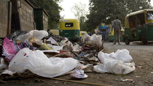 Müll und Unrat liegt neben Müllcontainern auf einem Markt in Neu-Delhi.