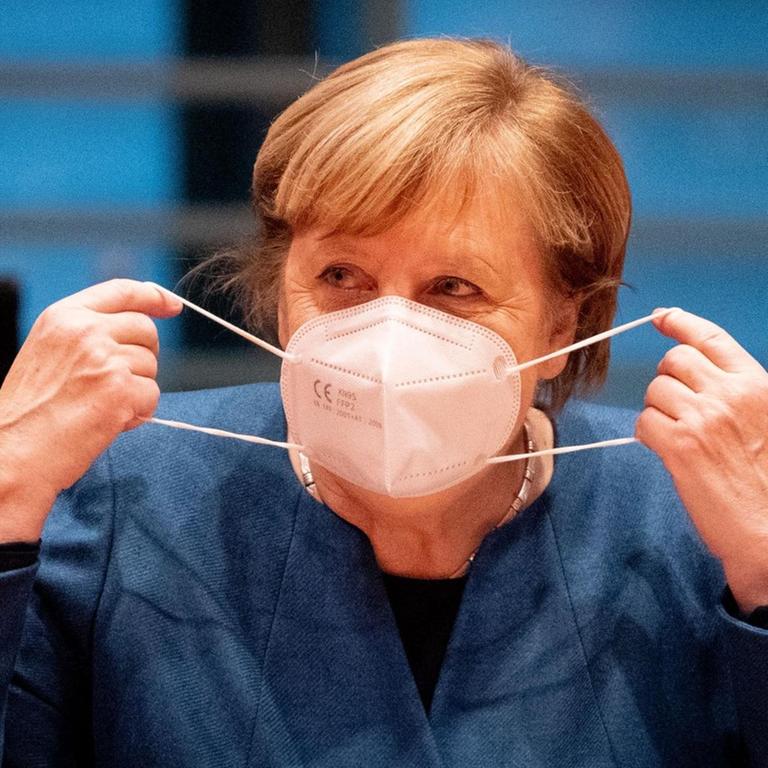 Bundeskanzlerin Angela Merkel (CDU) setzt zu Beginn der Sitzung des Bundeskabinetts im Bundeskanzleramt die Mund-Nasenbedeckung ab.