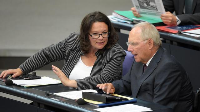 Bundesfinanzminister Schäuble und Bundesarbeitsministerin Nahles sitzen im Plenum nebeneinander und unterhalten sich.
