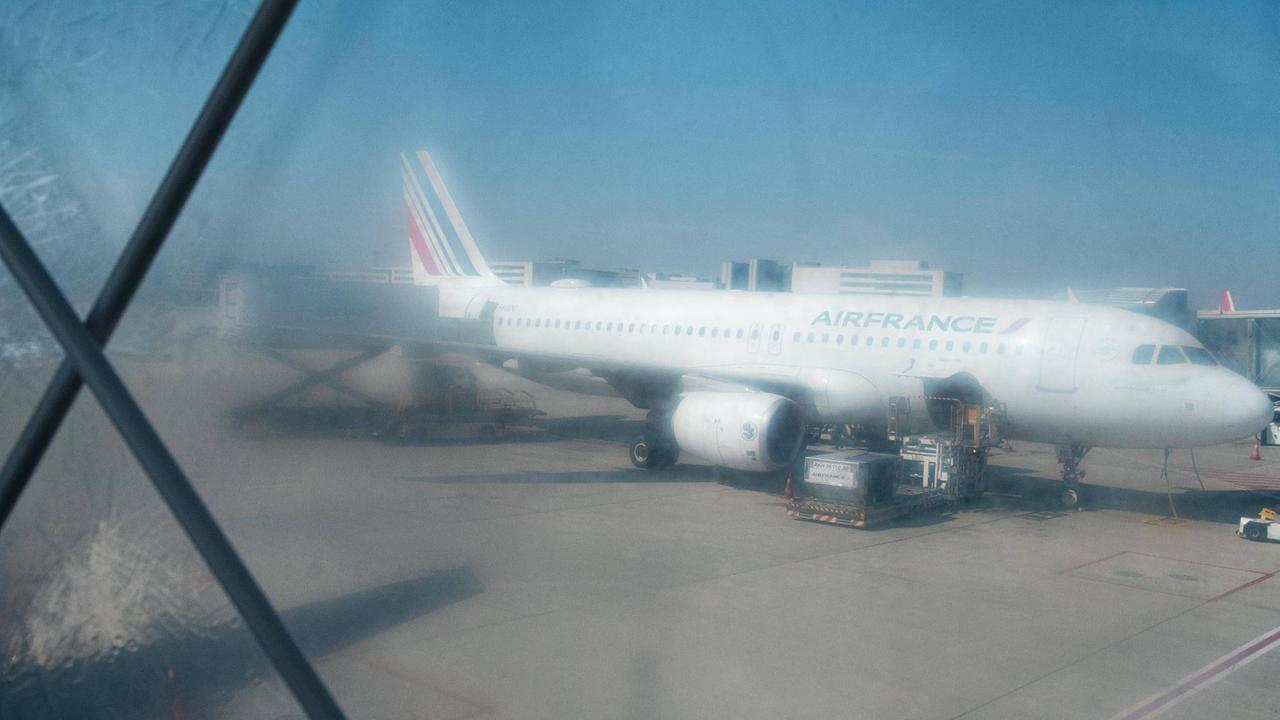 Ein Blick durch ein beschlagenes Fenster zeigt ein Flugzeug der Air France, das auf dem Boden steht. 
