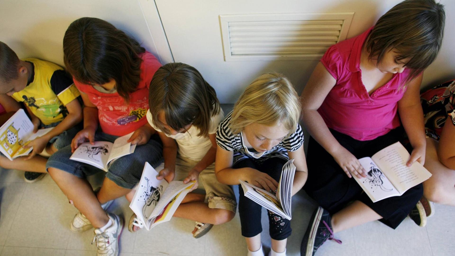 Jenn Ireland / The Californian.Second grader Abby Hobbs, center, flips through her brand new copy of Nate the Great , by author Marjorie Weinman Sharmat, while sitting with her classmates in the cafeteria of Wingland Elementary School Friday morning. Around 130 copies of the book were handed out to the school s second grade students by the North Bakersfield Rotary, in an effort to increase interest in reading at home and to improve reading skills. _