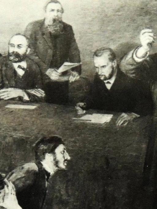 Zeichnung von Karl Marx, wie er vor einer Gruppe Männer redet, die sich Notizen machen.