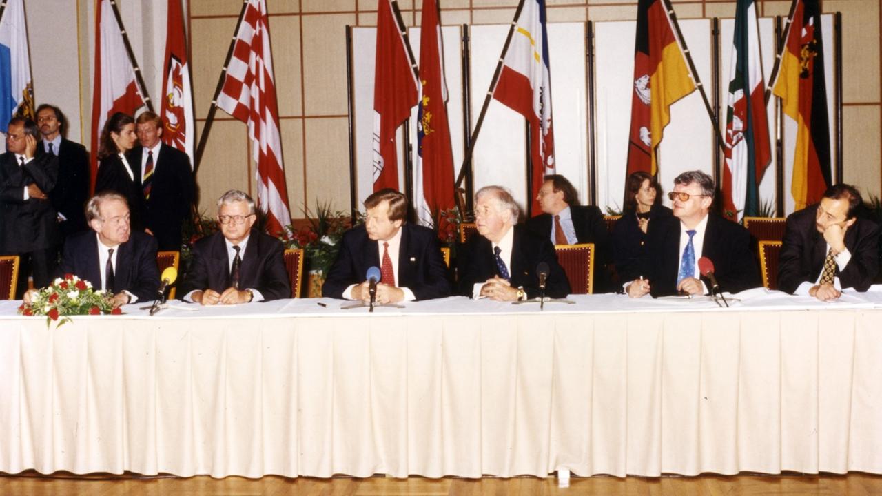 Die Unterzeichnung der Staatsverträge für die Gründung von Deutschlandradio. Im Hintergrund sind Fahnen verschiedener Bundesländer zu sehen. Die Unterzeichnung der Staatsverträge für die Gründung von Deutschlandradio. Im Hintergrund sind Fahnen verschiedener Bundesländer zu sehen.
