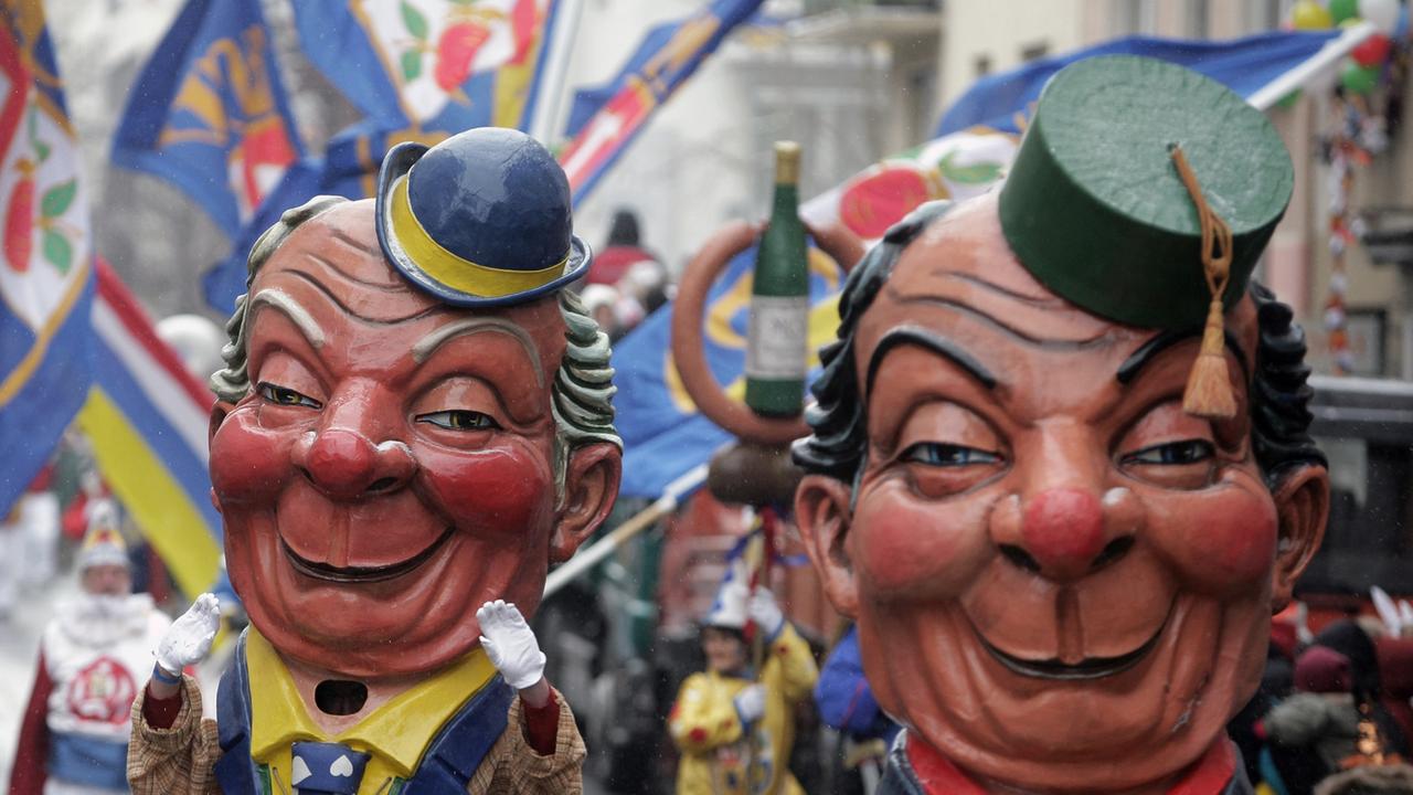 Riesige Karnevalsmasken über dem Rosenmontagsumzug von Mainz