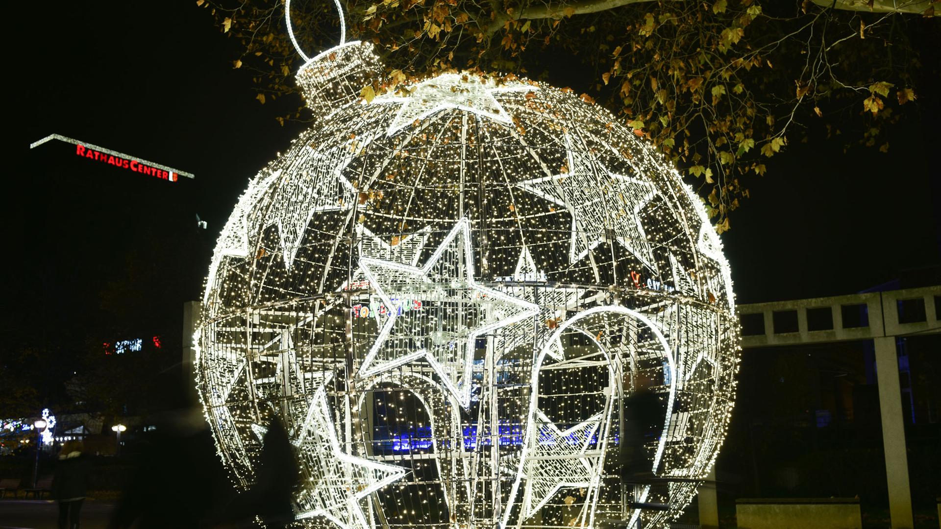 Besucher laufen am 24.11.2014 in Ludwigshafen (Rheinland-Pfalz) an einer begehbaren, beleuchteten Weihnachtskugel vorbei. Nach Angaben der Stadt handelt es sich um die größte ihrer Art in Deutschland. Sie besteht aus einem fünf Meter hohen, runden Metallgerippe, um das herum 20 000 LED-Lichter angebracht sind. Besucher laufen am 24.11.2014 in Ludwigshafen (Rheinland-Pfalz) an einer begehbaren, beleuchteten Weihnachtskugel vorbei. Nach Angaben der Stadt handelt es sich um die größte ihrer Art in Deutschland. Sie besteht aus einem fünf Meter hohen, runden Metallgerippe, um das herum 20 000 LED-Lichter angebracht sind.