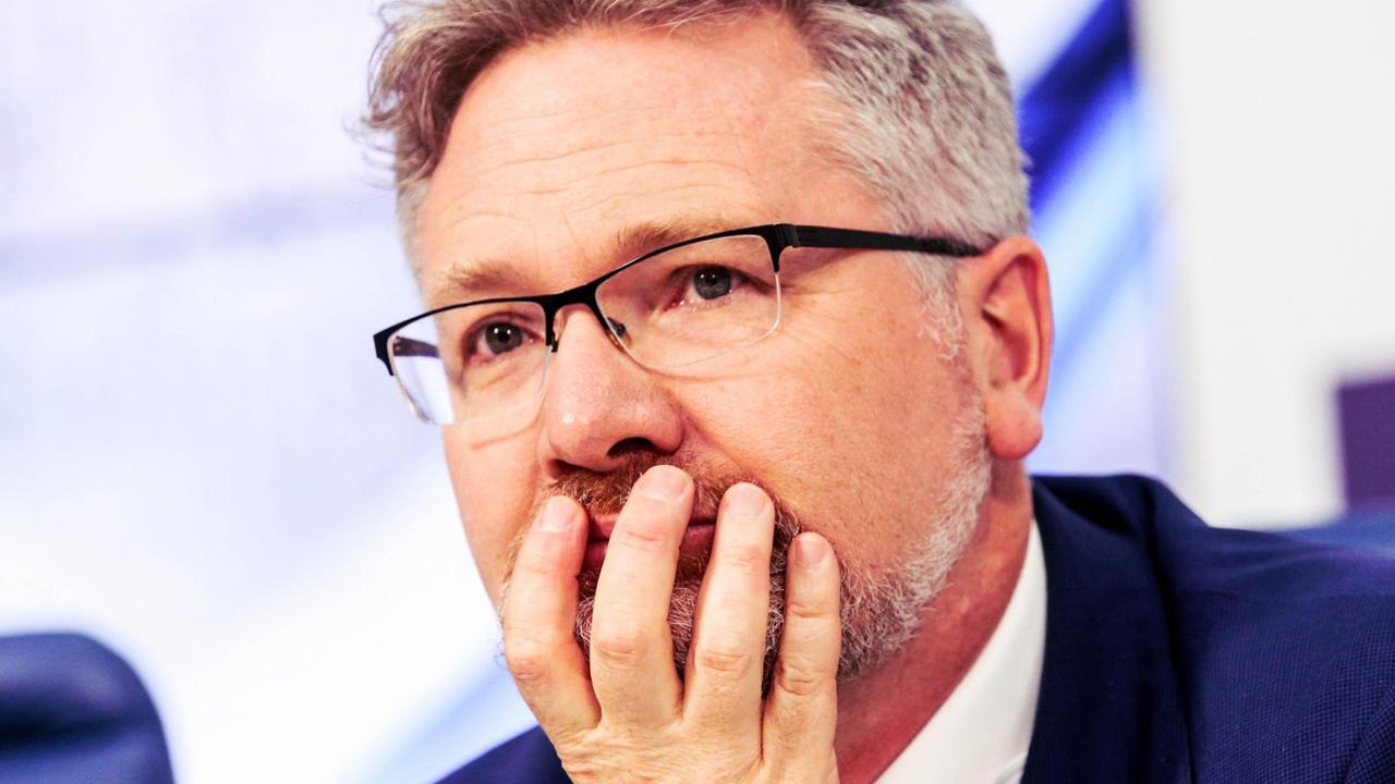Adam Tooze auf einer Pressekonferenz. Er hält mit sorgenvoller Mine die Hand am Kinn. Adam Tooze auf einer Pressekonferenz. Er hält mit sorgenvoller Mine die Hand am Kinn.