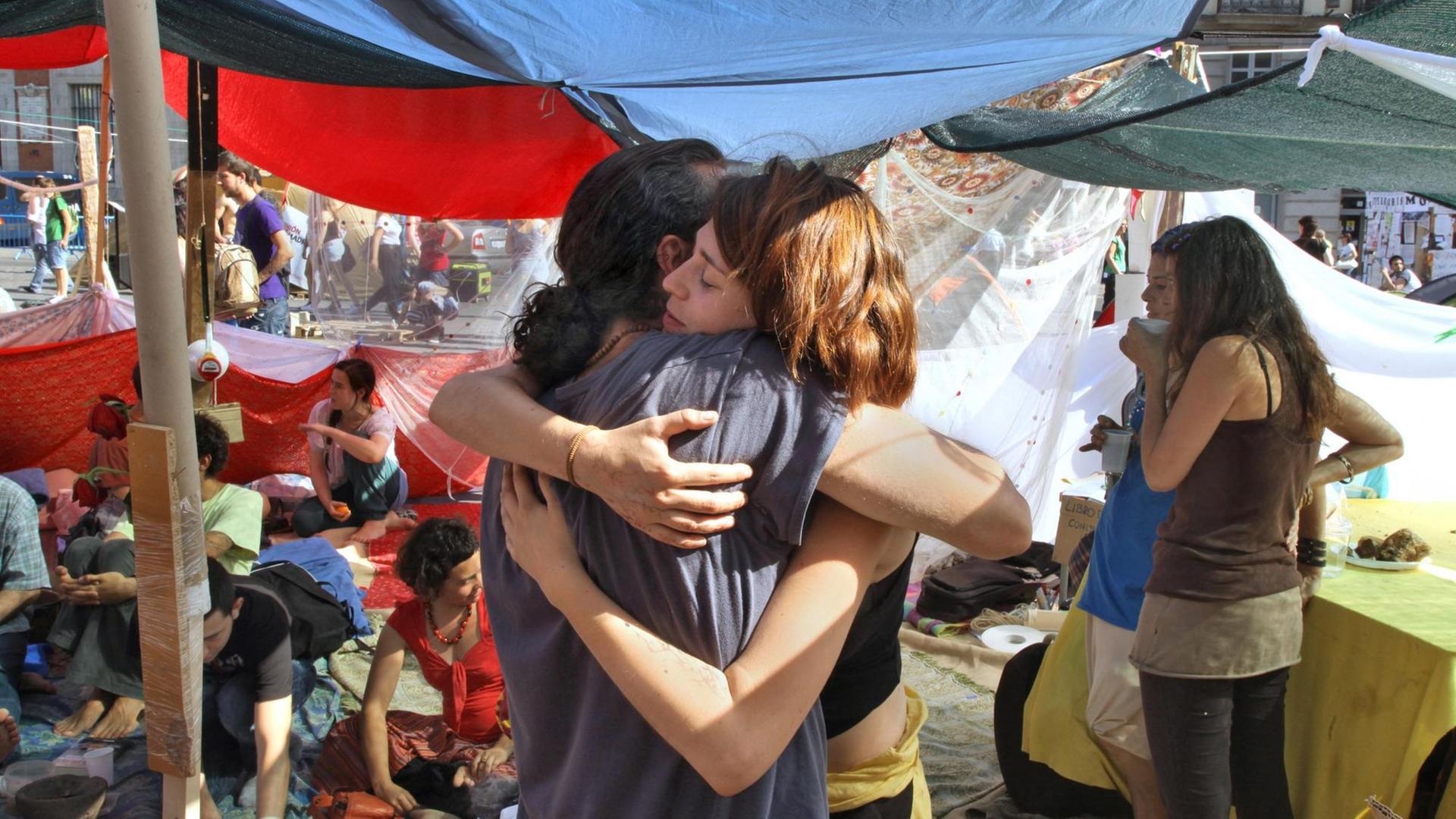 Ein junges Paar umamrt sich während des Protest-Camps auf der Puerta del Sol im Mai 2011. Ein junges Paar umamrt sich während des Protest-Camps auf der Puerta del Sol im Mai 2011.