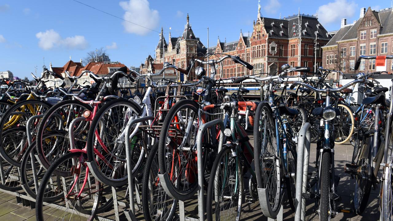 Fahrräder stehen vor dem Haupteingang des Bahnhofs Amsterdam Central (aufgenommen 2015)