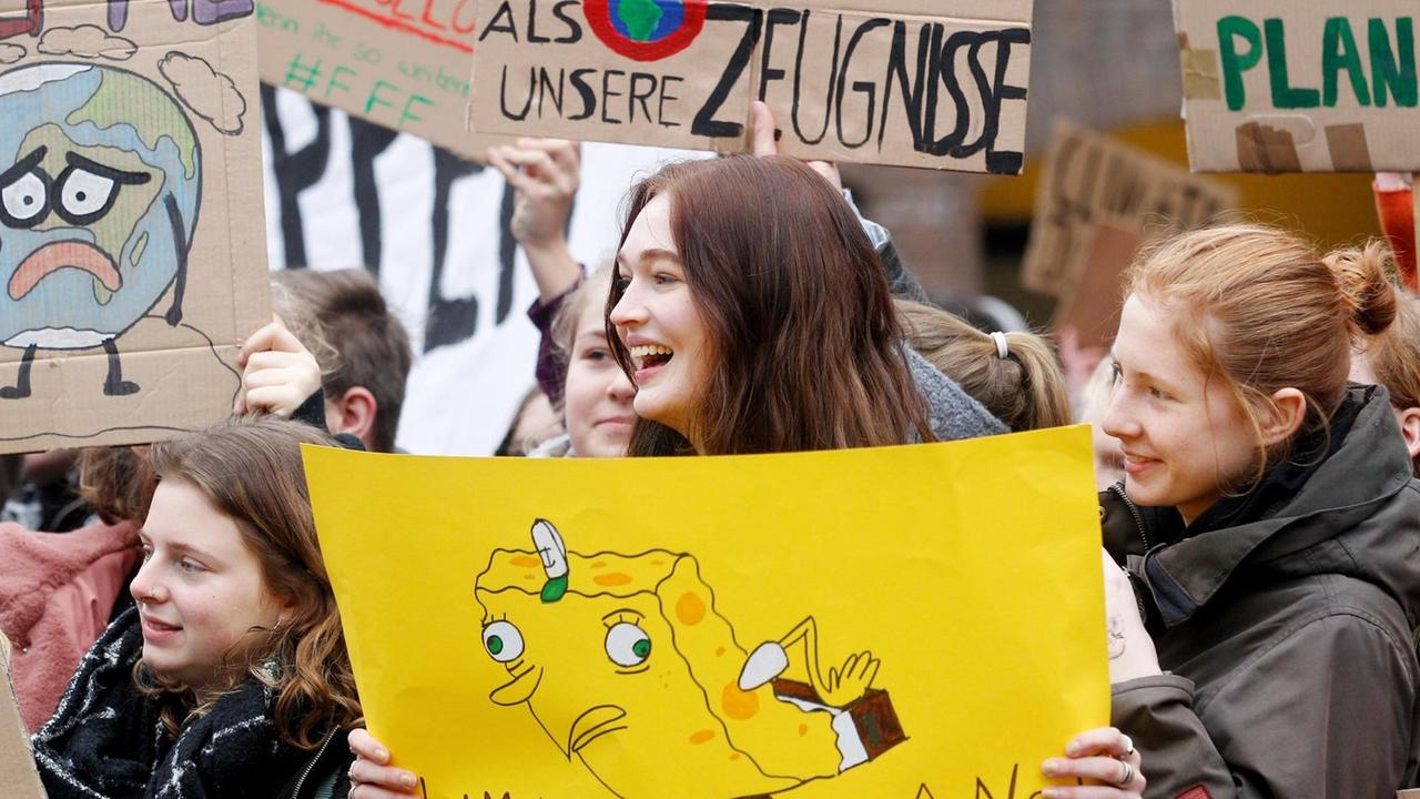 Schüler protestieren während einer Schülerdemonstration vor dem Düsseldorfer Rathaus mit einem Plakat "Unser Klima hat mehr Defizite als unsere Zeugnisse". Der Protest steht unter dem Motto "Fridays for Future". Schüler protestieren während einer Schülerdemonstration vor dem Düsseldorfer Rathaus mit einem Plakat "Unser Klima hat mehr Defizite als unsere Zeugnisse". Der Protest steht unter dem Motto "Fridays for Future".