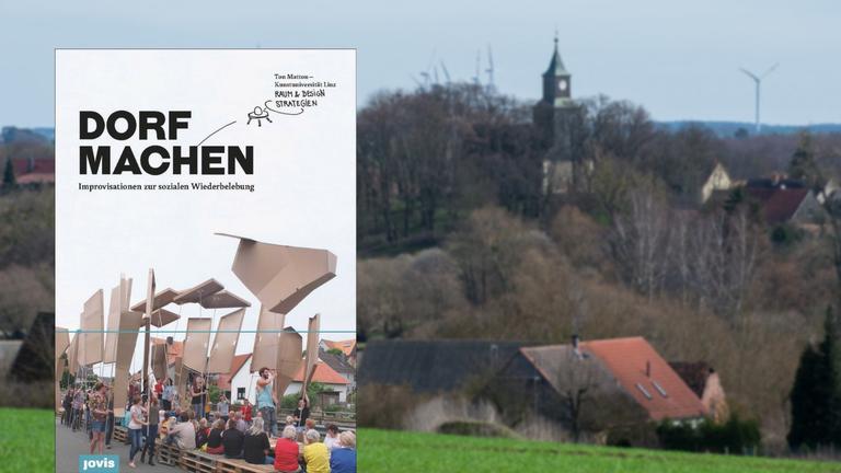 Ton Mattons Buch "Dorf machen" vor dem Hintergrund einer Aufnahme eines idyllischen Dorfes. ("Dorf machen" / Ton Matton (Hg) / Jovis Verlag; Imago / Patrick Pleul)