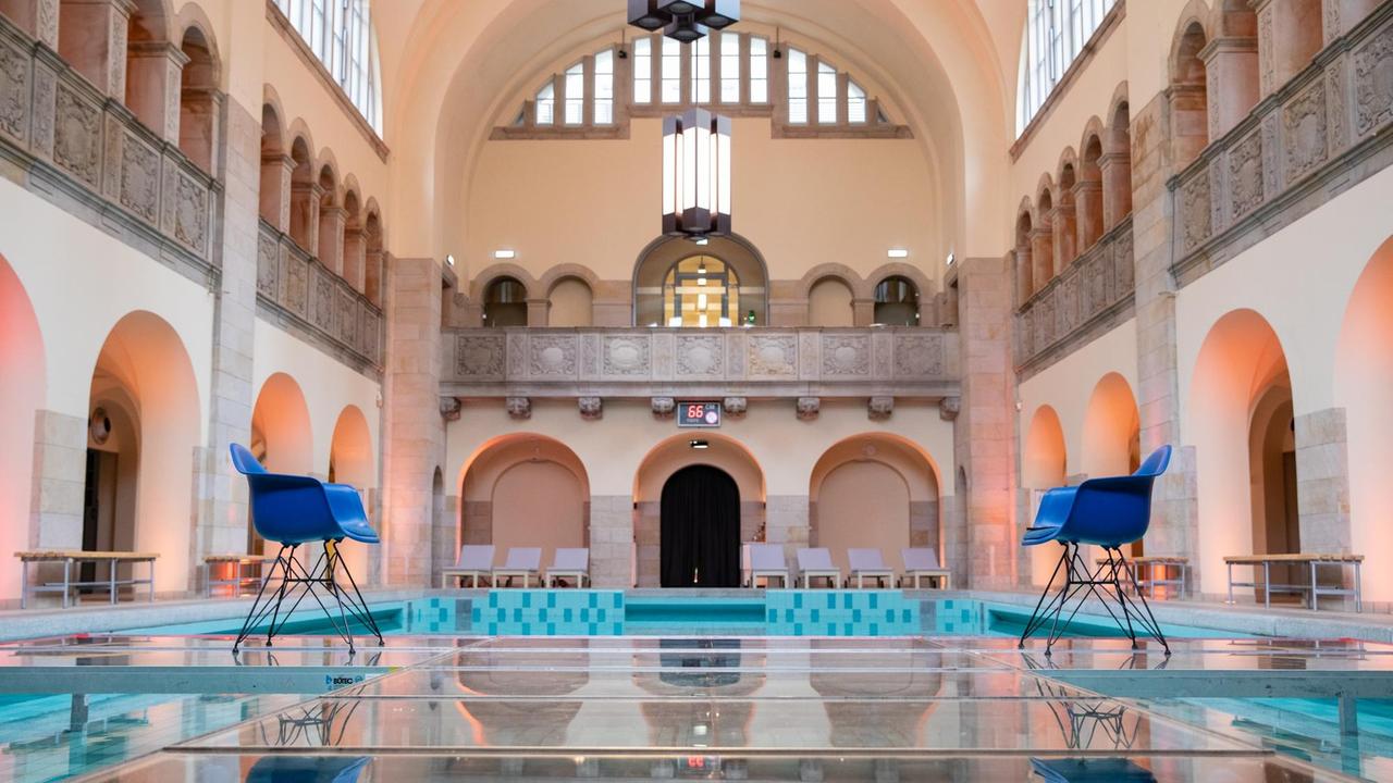 Zwei Stühle stehen einander auf einem Podest im ehemaligen Stadtbad gegenüber. Zwei Stühle stehen einander auf einem Podest im ehemaligen Stadtbad gegenüber.