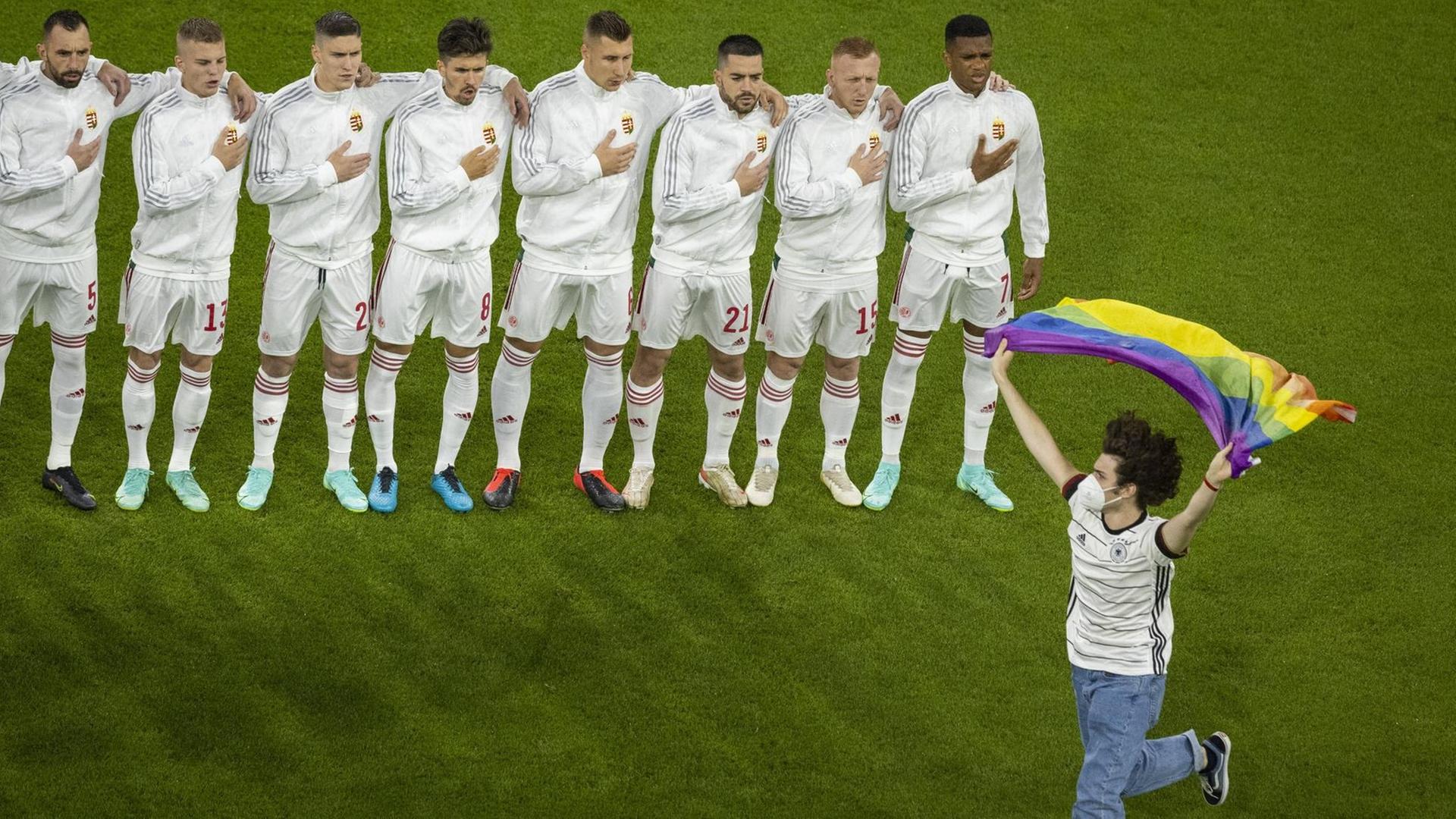 Flitzer mit Regenbogenfahne während der Hymne von Ungarn beim EM-Spiel Deutschland - Ungarn. Flitzer mit Regenbogenfahne während der Hymne von Ungarn beim EM-Spiel Deutschland - Ungarn.