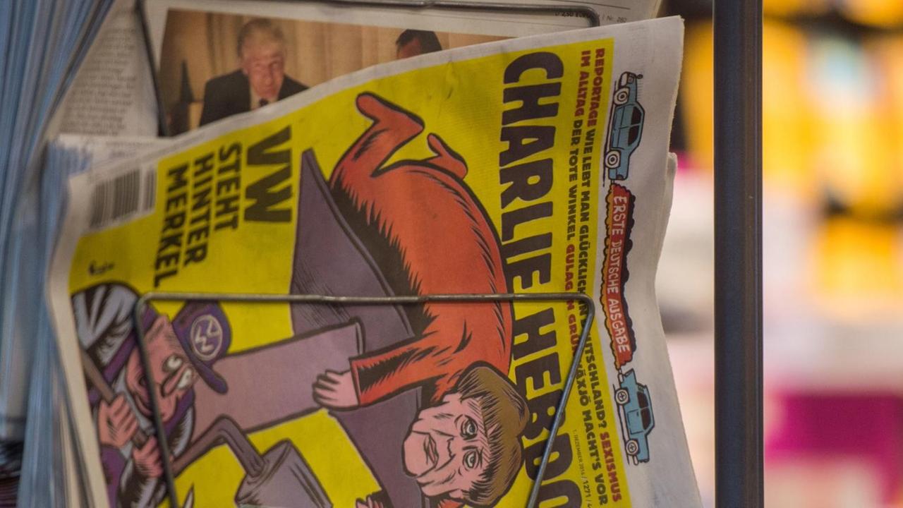 Ausgaben der französischen Satire-Zeitschrift Charlie Hebdo hängen am 01.12.2016 in Stuttgart (Baden-Württemberg) in einem Zeitungsständer eines Kiosks. Ausgaben der französischen Satire-Zeitschrift Charlie Hebdo hängen am 01.12.2016 in Stuttgart (Baden-Württemberg) in einem Zeitungsständer eines Kiosks.
