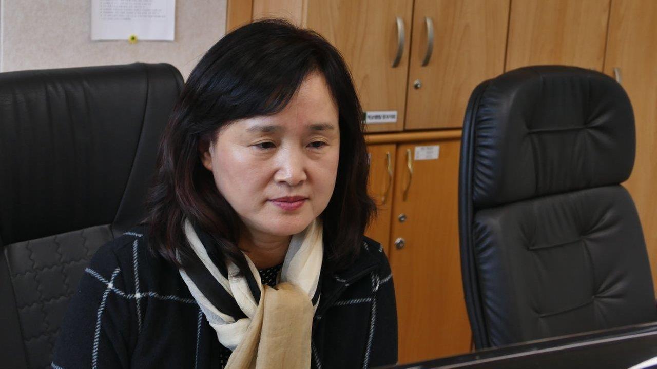 Schuldirektorin Kim Hee-su im Büro am Schreibtisch.