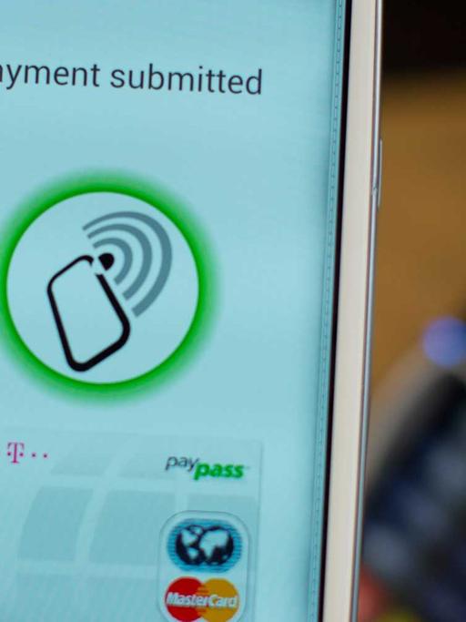 Ein Handy mit der Nahbereichskommunikationstechnik NFC Near Field Communication wird am 27.11.2012 beim Trendkongress der Bitkom in Berlin mit der App MyWallet der Telekom an ein Bezahlterminal gehalten.