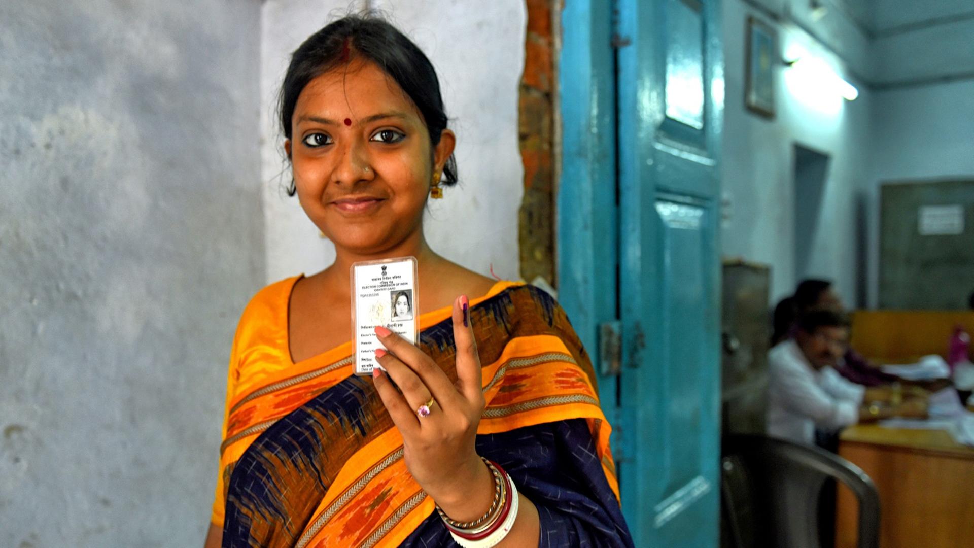 Eine junge Frau zeigt nach ihrer Stimmabgabe am 6.5.2019 in Barakpur, Westbengalen, ihren mit Tinte markierten Finger.