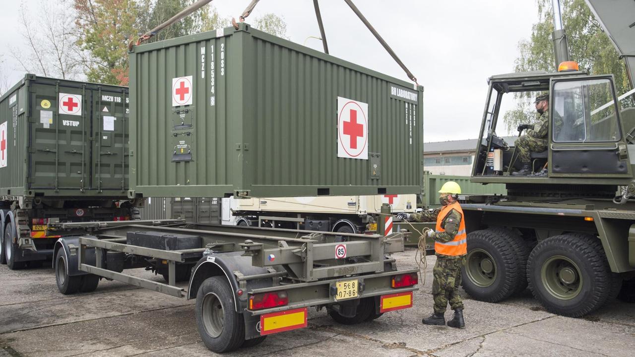 Ein Container mit medizinischem Gerät wird auf den Anhänger eines LKWs geladen. Ein Container mit medizinischem Gerät wird auf den Anhänger eines LKWs geladen.