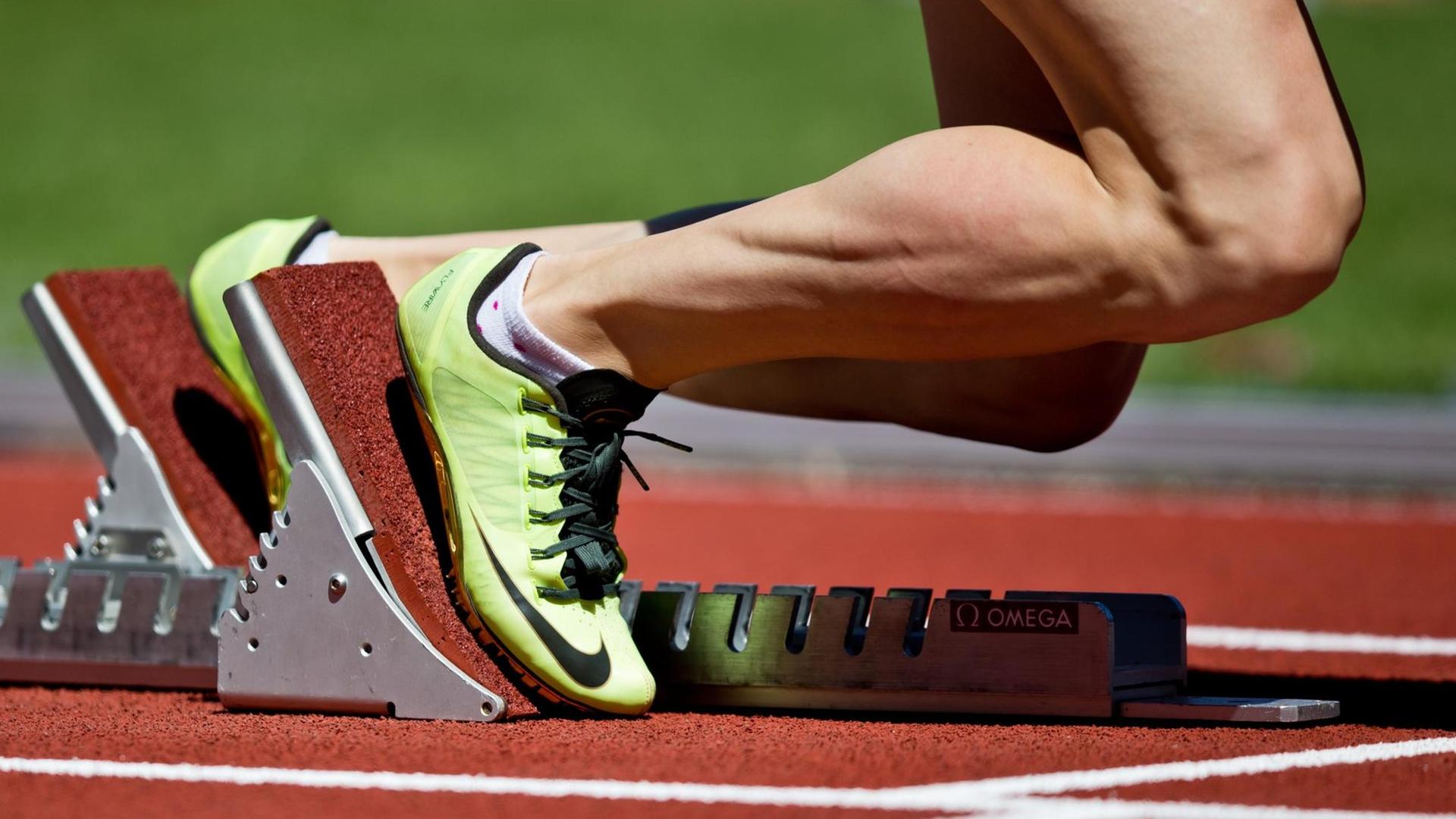 Eine Leichtathletin steht im Startblock Eine Leichtathletin steht im Startblock