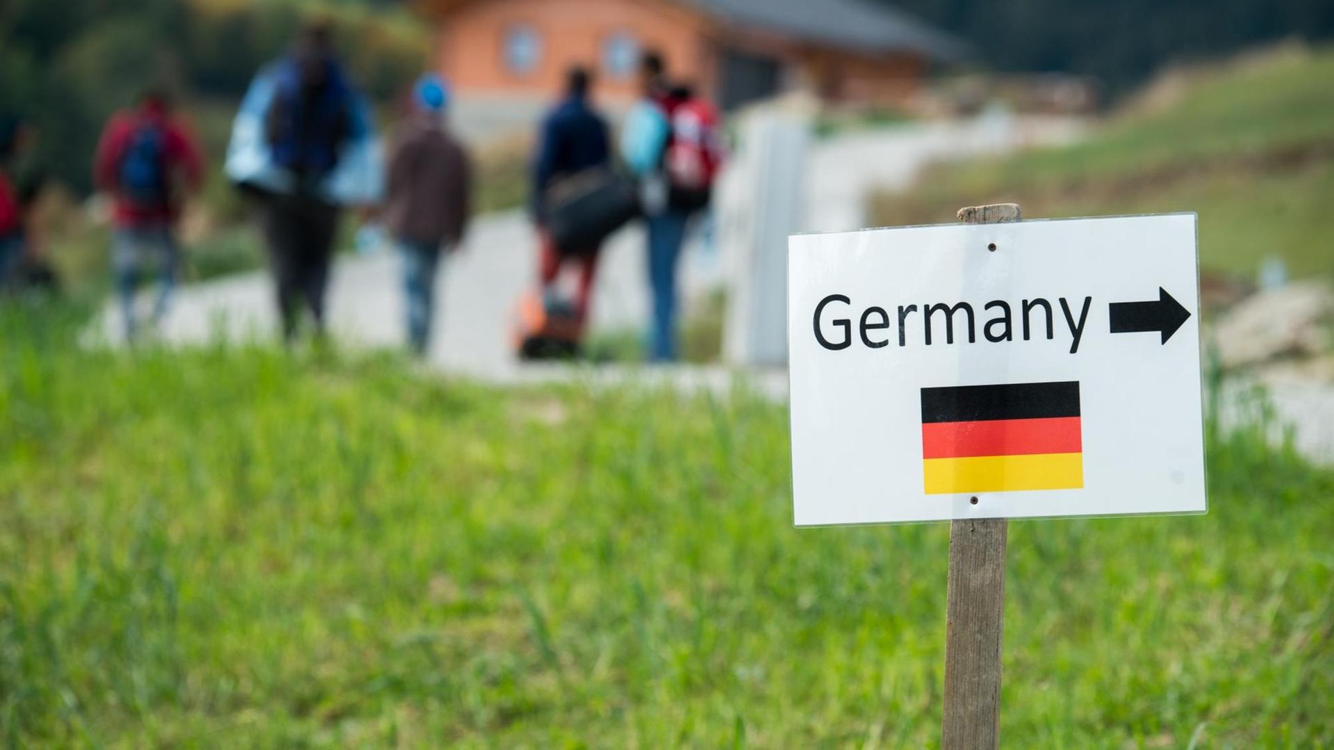 Flüchtlinge auf dem Weg von Österreich nach Bayern. Ein Schild weist den Weg nach Deutschland. Flüchtlinge auf dem Weg von Österreich nach Bayern. Ein Schild weist den Weg nach Deutschland.