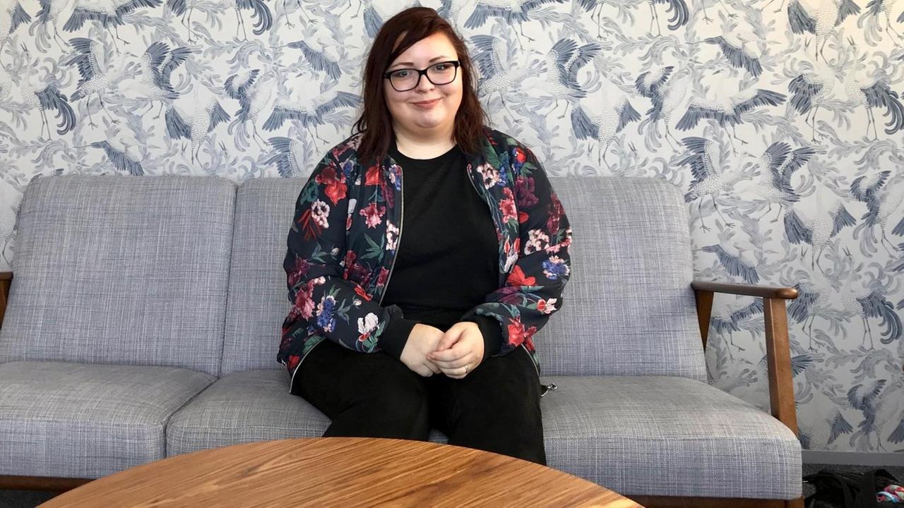 Karolina Korhonen sitzt auf einem Sofa Karolina Korhonen sitzt auf einem Sofa