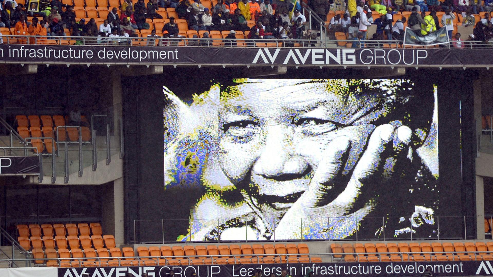 Im mit Menschen gefüllten Fußballstadion von Johannesburg hängt ein Mandela-Plakat Im mit Menschen gefüllten Fußballstadion von Johannesburg hängt ein Mandela-Plakat
