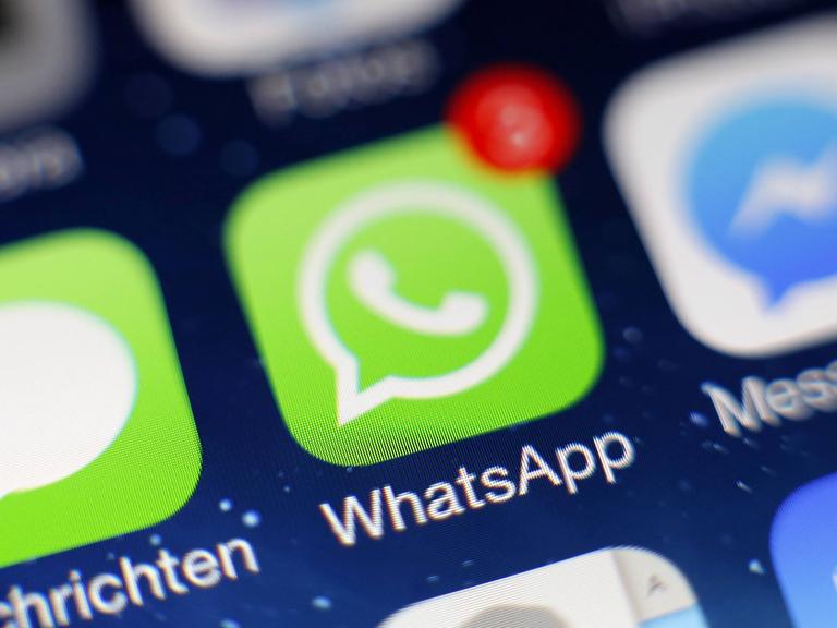 Das WhatsApp-Icon ist auf dem Display eines iPhones zu sehen.
