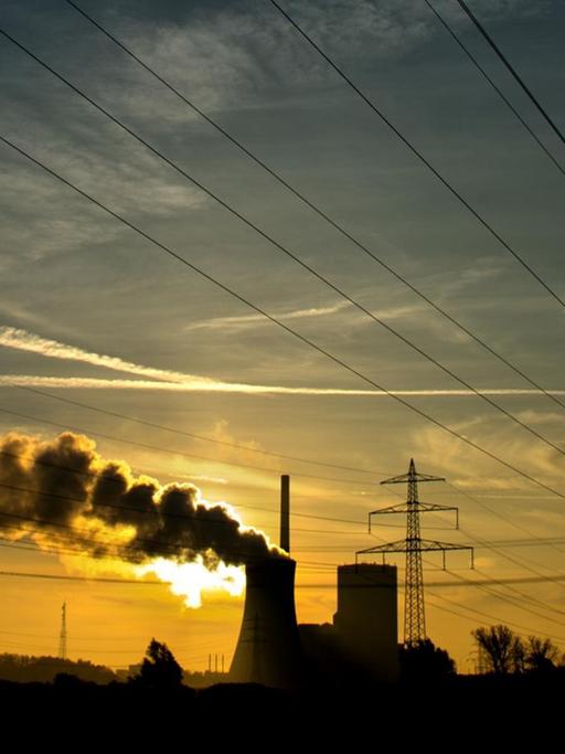 Die aufgehende Sonne taucht am 27.10.2014 den Himmel hinter dem Kohlekraftwerk Mehrum in Hohenhameln im Landkreis Peine (Niedersachsen) in warmes Licht.