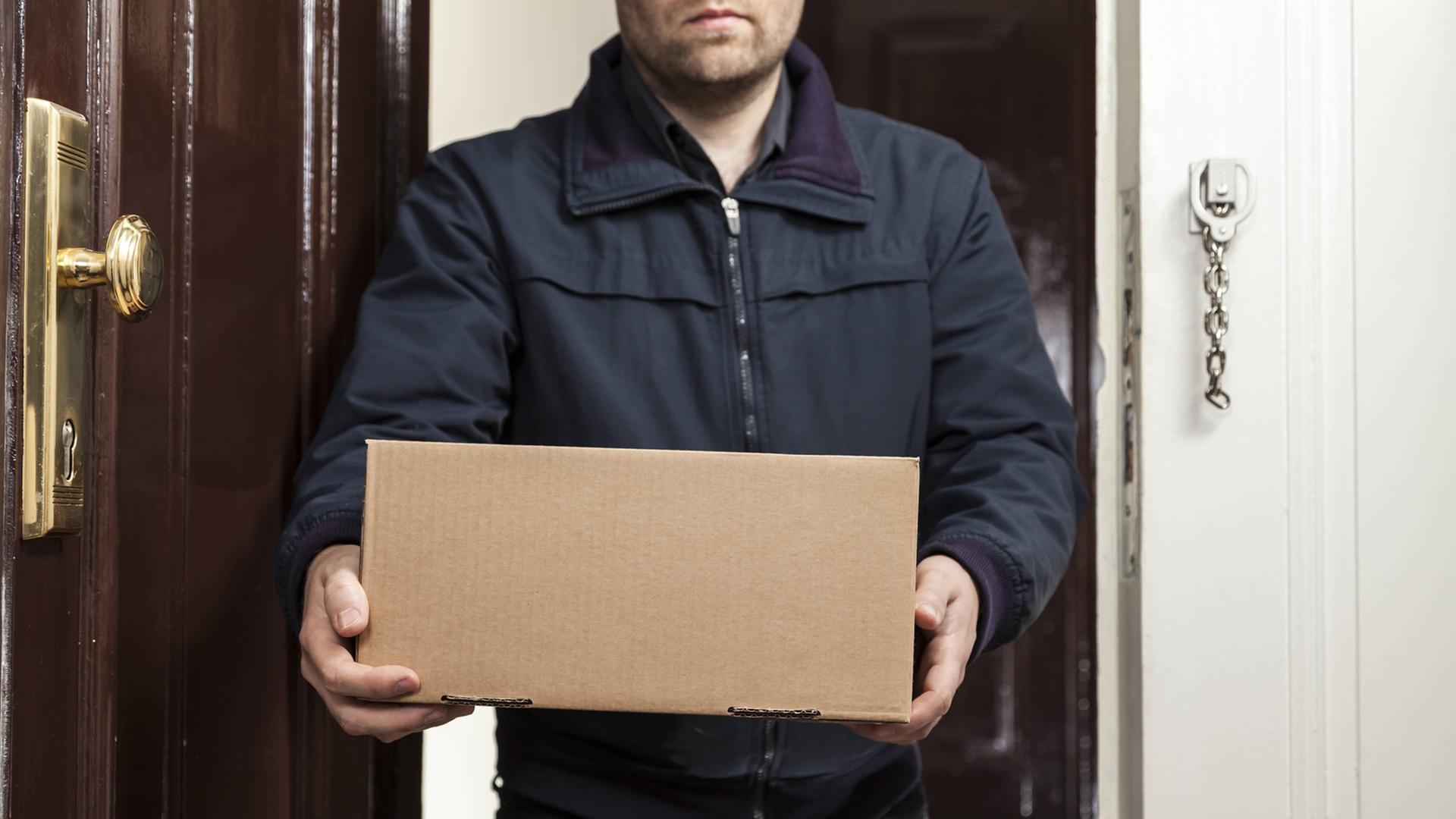 Ein Postbote bringt ein Paket an die Haustüre. Ein Postbote bringt ein Paket an die Haustüre.