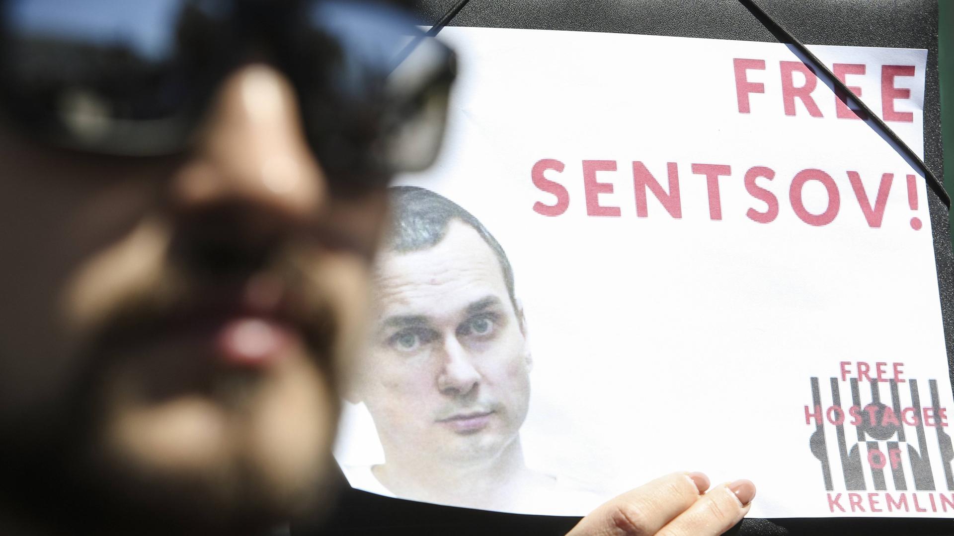 Menschen in Kiew zeigen Protestplakate mit der Forderungan an die russische Regierung nach einer Freilassung des Künstlers Oleg Senzow Menschen in Kiew zeigen Protestplakate mit der Forderungan an die russische Regierung nach einer Freilassung des Künstlers Oleg Senzow