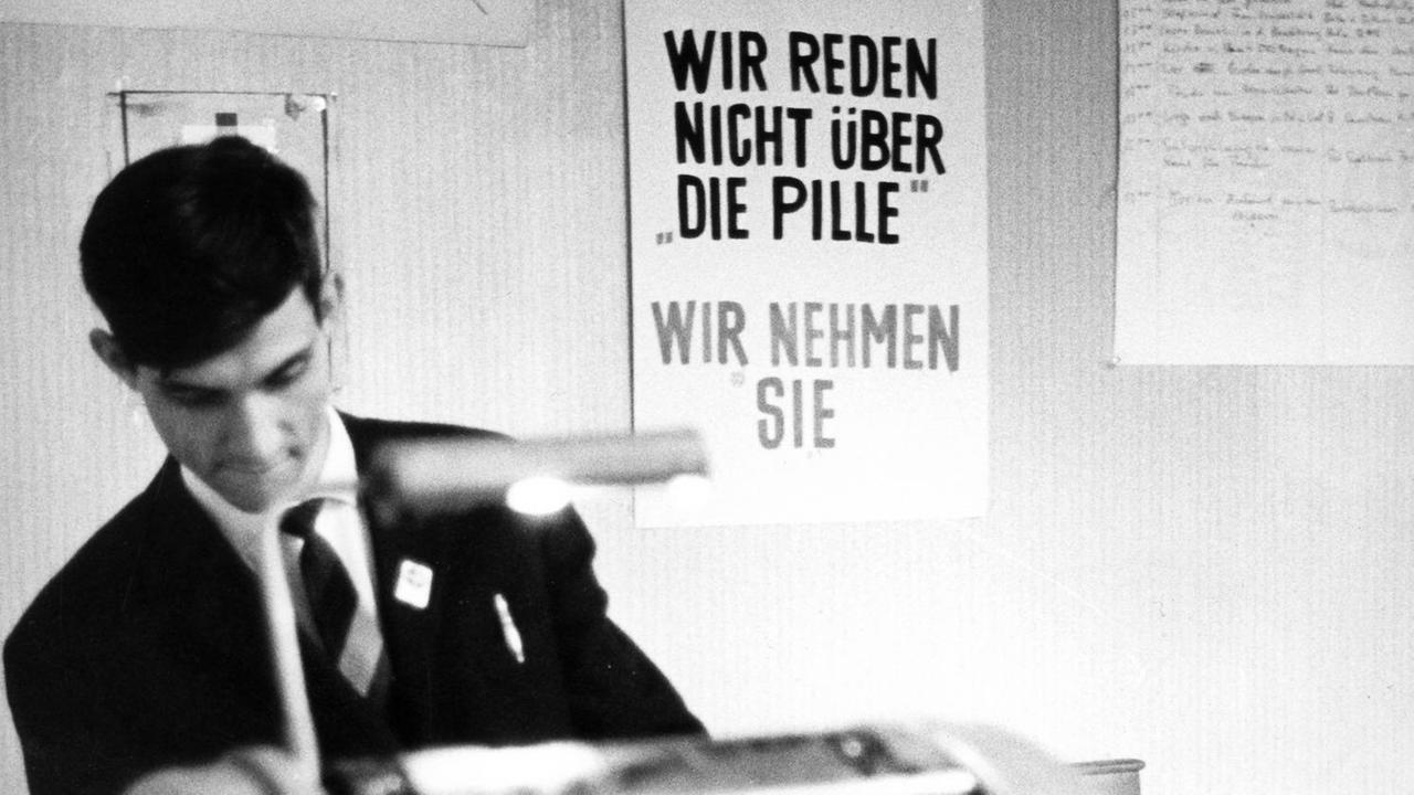 Ein Mitglied des Aktionszentrums steht am 04.09.1968 anlässlich des 82. Deutschen Katholikentages in Essen an einer Vervielfältigungsmaschine, im Hintergrund ein Schild mit der Aufschrift "Wir reden nicht über die Pille - Wir nehmen sie". Eine eigene Zeitung unter dem Titel "Kritischer Katholizismus", will das Aktionszentrum "Kritischer Katholikentag", dem etwa 150 Mitglieder katholischer Gruppen angehören, während der Zeit des Katholikentages herausbringen. Das Aktionszentrum hatte am 04.09.1968 die in Essen anwesenden Gläubigen aufgefordert, Papst Paul VI. wegen der Ehe-Enzyklika "Humanae Vitae" das Misstrauen auszusprechen und ihn zum Rücktritt aufzufordern. Außer der Zeitung will das Aktionszentrum in allen Foren mitdiskutieren. Für den Fall, dass man dort nicht zu Wort kommen sollte, hat das Zentrum Demonstrationen angekündigt. Ein Mitglied des Aktionszentrums steht am 04.09.1968 anlässlich des 82. Deutschen Katholikentages in Essen an einer Vervielfältigungsmaschine, im Hintergrund ein Schild mit der Aufschrift "Wir reden nicht über die Pille - Wir nehmen sie". Eine eigene Zeitung unter dem Titel "Kritischer Katholizismus", will das Aktionszentrum "Kritischer Katholikentag", dem etwa 150 Mitglieder katholischer Gruppen angehören, während der Zeit des Katholikentages herausbringen. Das Aktionszentrum hatte am 04.09.1968 die in Essen anwesenden Gläubigen aufgefordert, Papst Paul VI. wegen der Ehe-Enzyklika "Humanae Vitae" das Misstrauen auszusprechen und ihn zum Rücktritt aufzufordern. Außer der Zeitung will das Aktionszentrum in allen Foren mitdiskutieren. Für den Fall, dass man dort nicht zu Wort kommen sollte, hat das Zentrum Demonstrationen angekündigt.